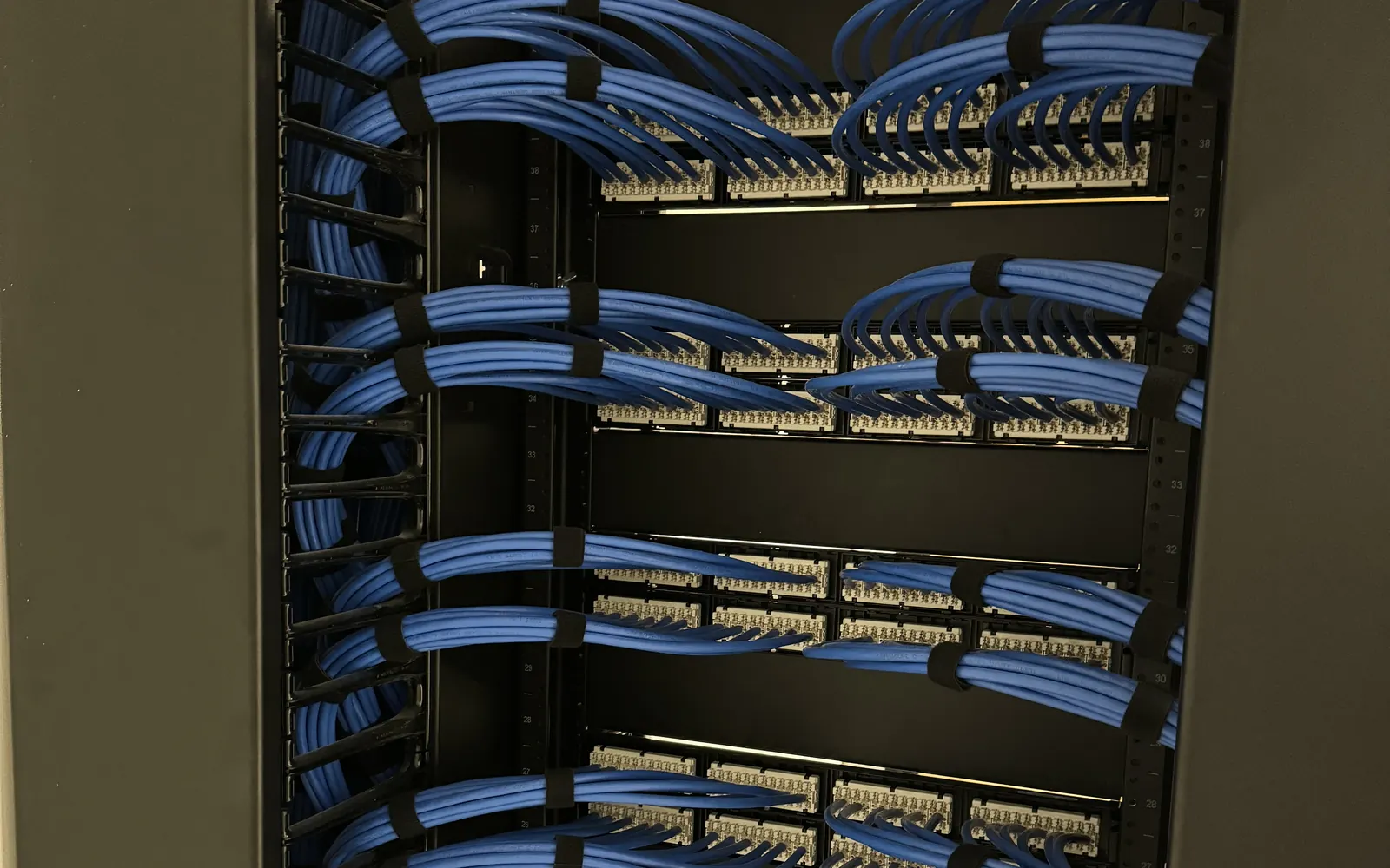 Rear of Category 6A patch panels with cable bundles dressed and strapped in a two-post rack