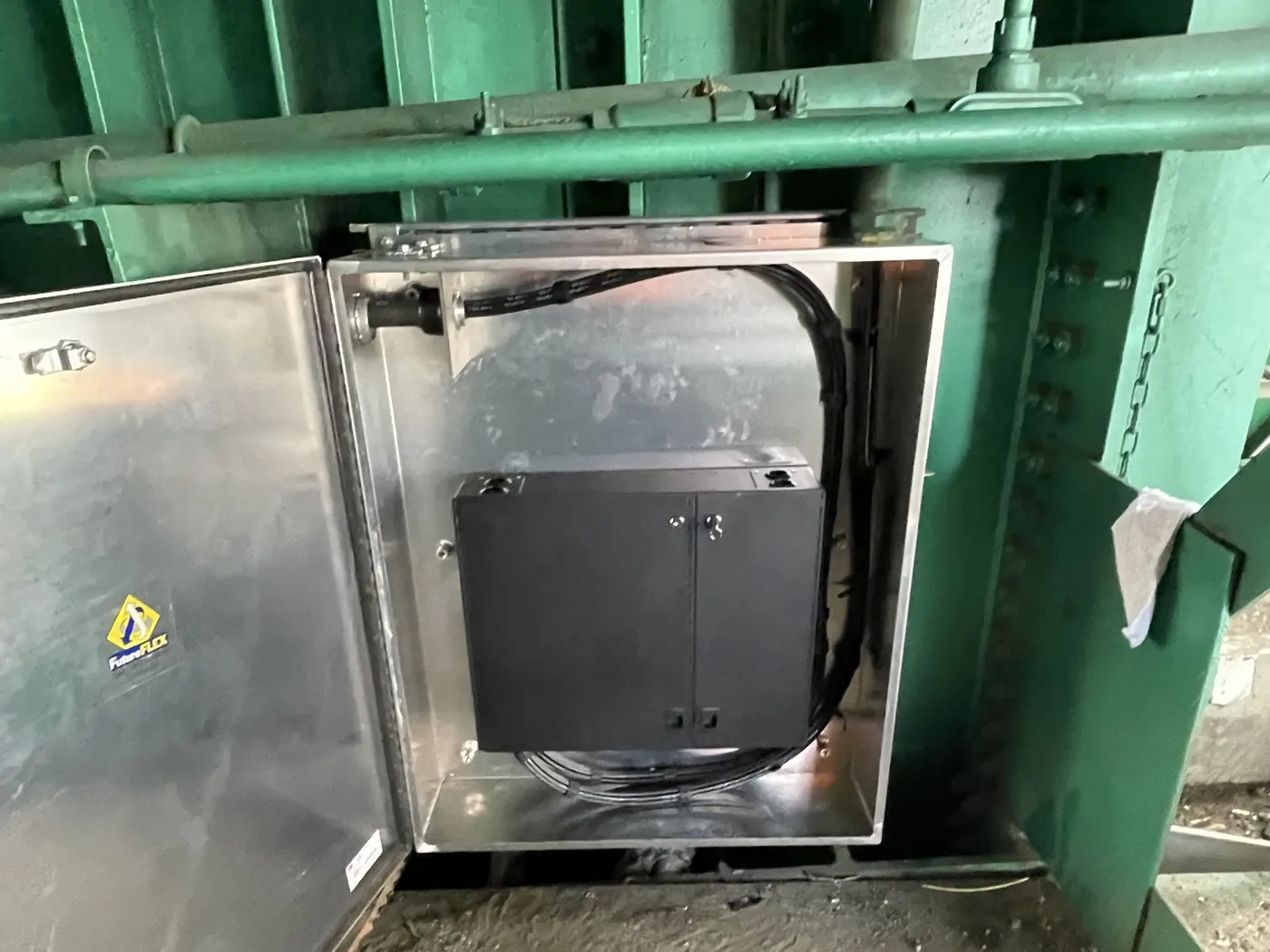 Open enclosure under the bridge deck showing the splice center and coiled tube